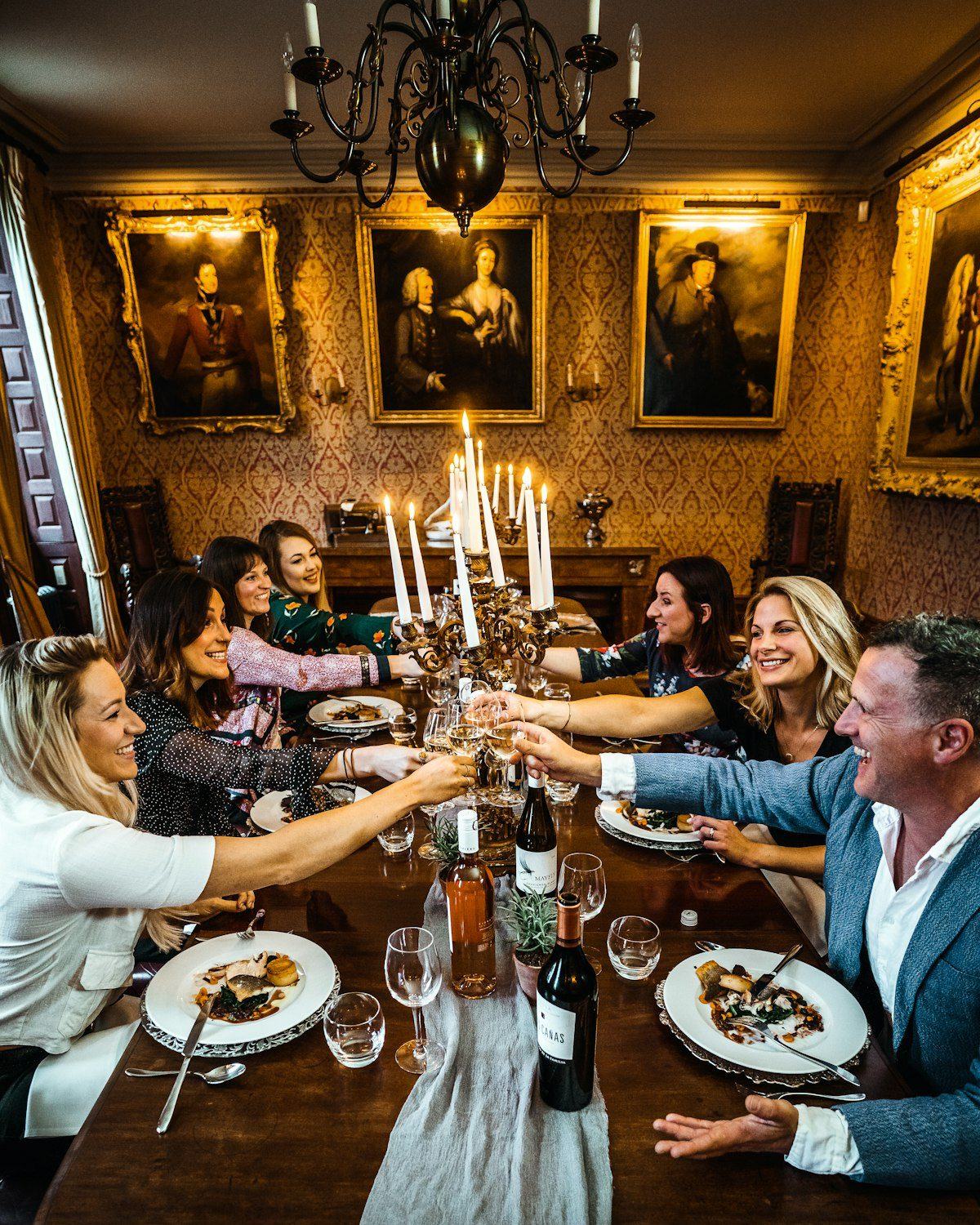 Guests raising glasses at a candlelit dinner table