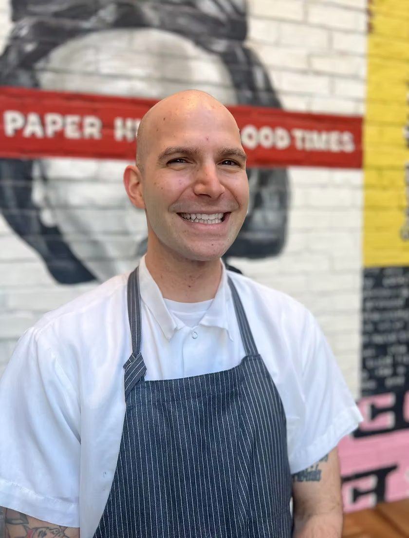 Chef Charlie Weintraub in whites and a striped apron