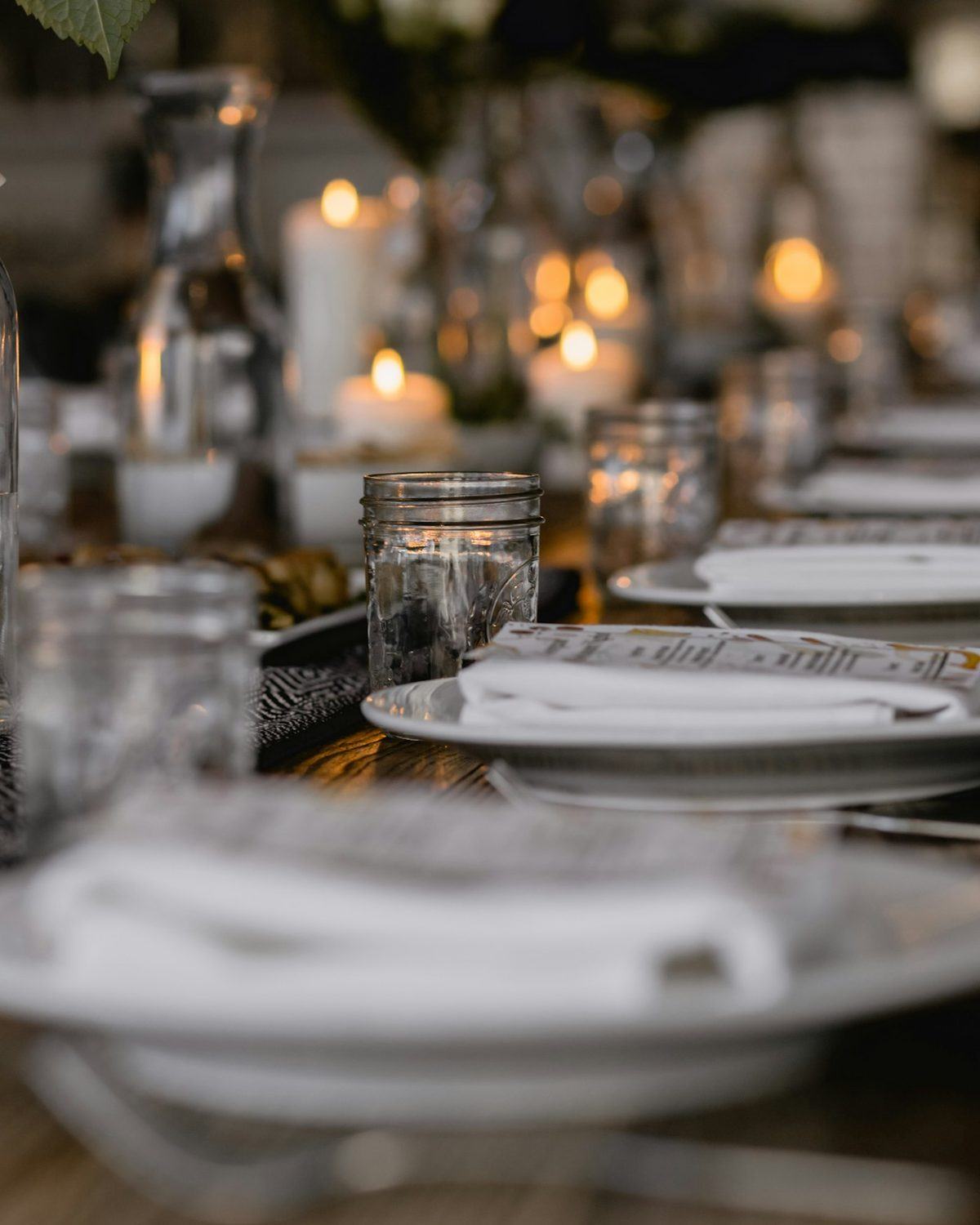 A long event table with candles and glassware
