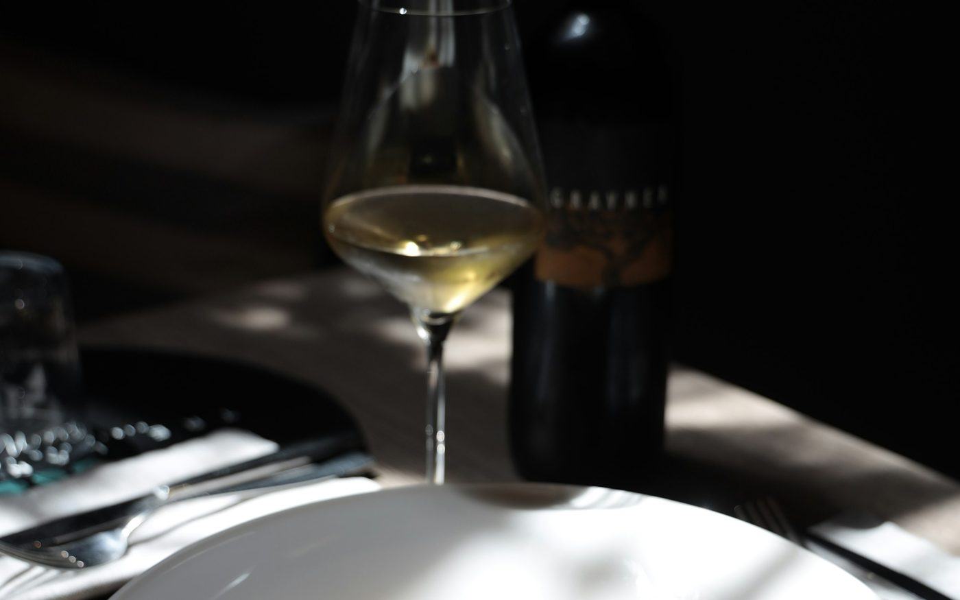 A glass of white wine at a set table
